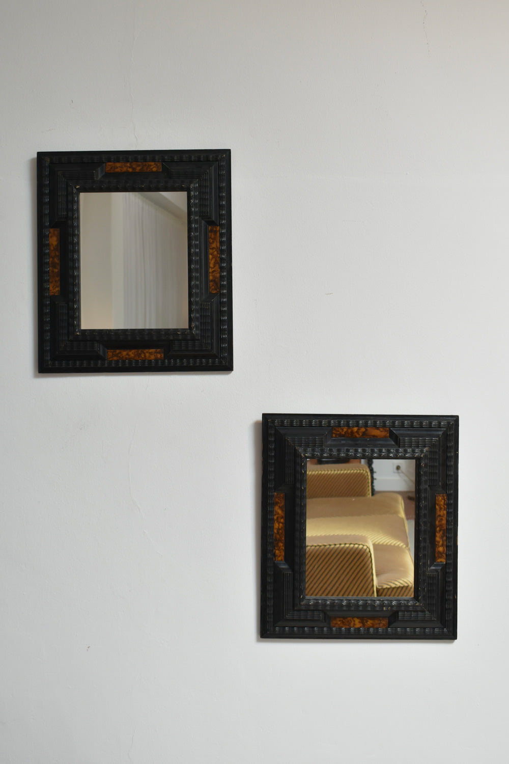 Pair of carved ebonised wood and trompe l'oeil turshell mirrors, XIXth c.