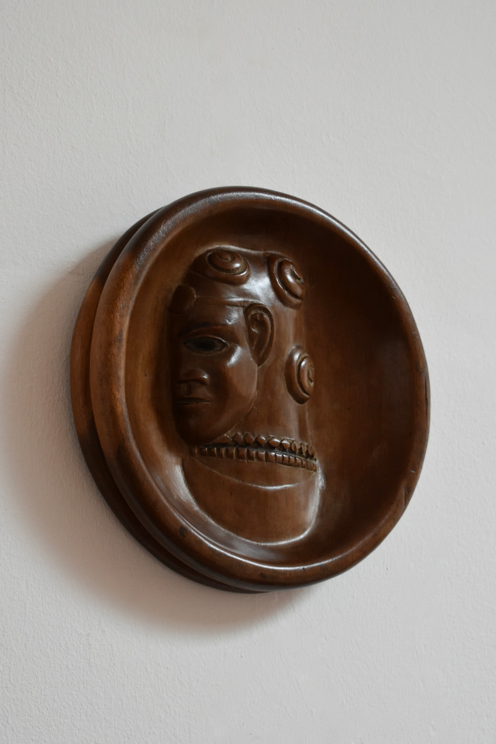 Africanist low relief round wooden wall sculpture, 1970s.
