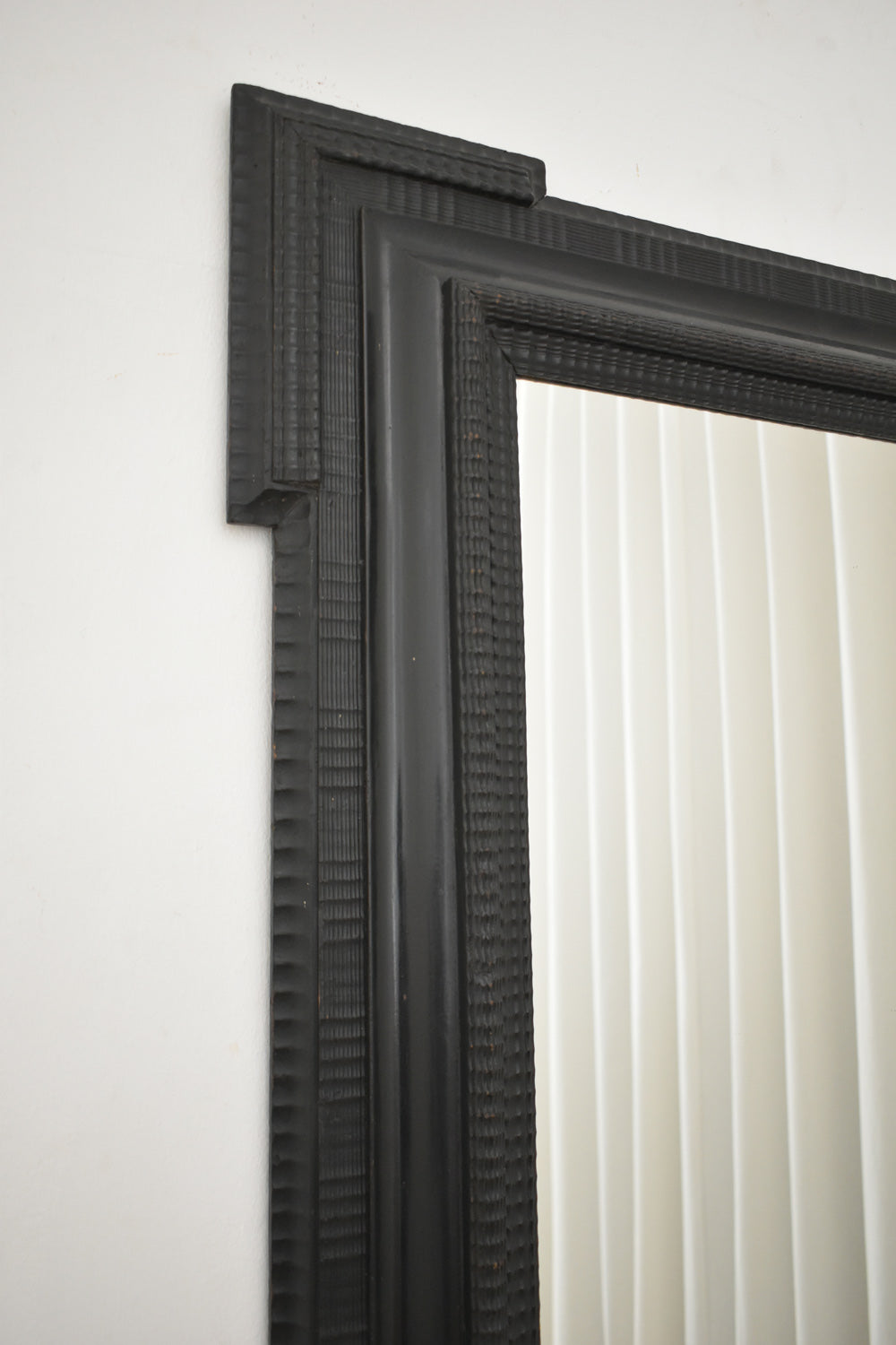 Carved ebonised wooden mirror, XIXth c.