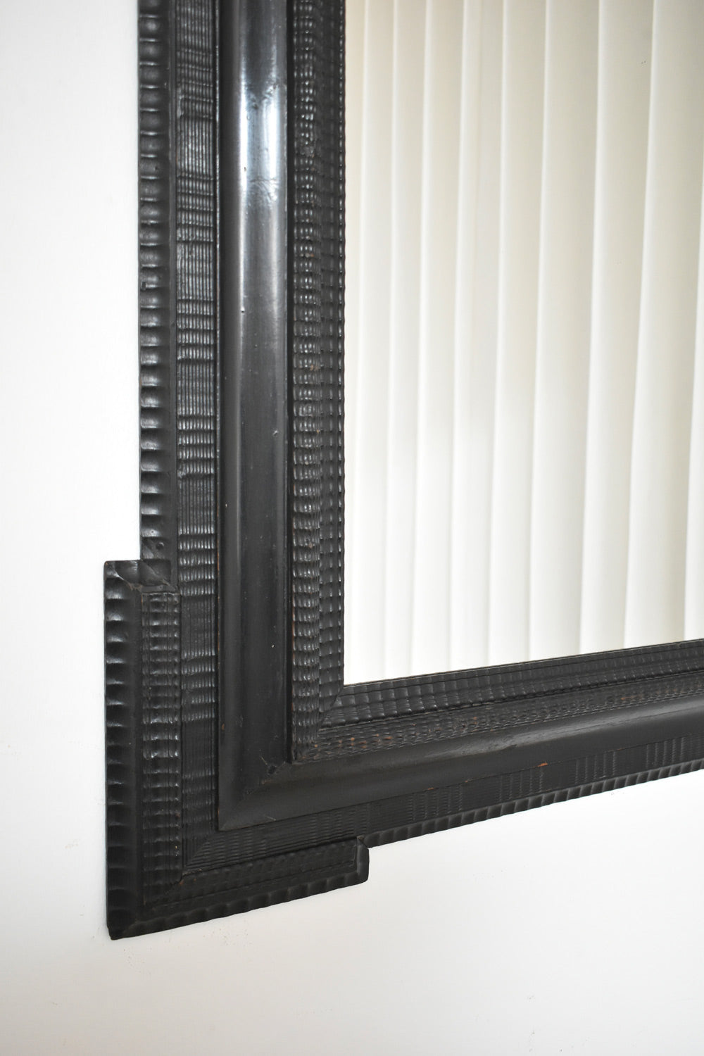 Carved ebonised wooden mirror, XIXth c.