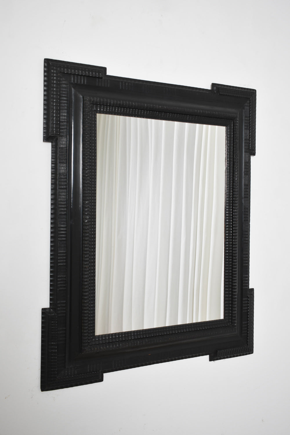 Carved ebonised wooden mirror, XIXth c.
