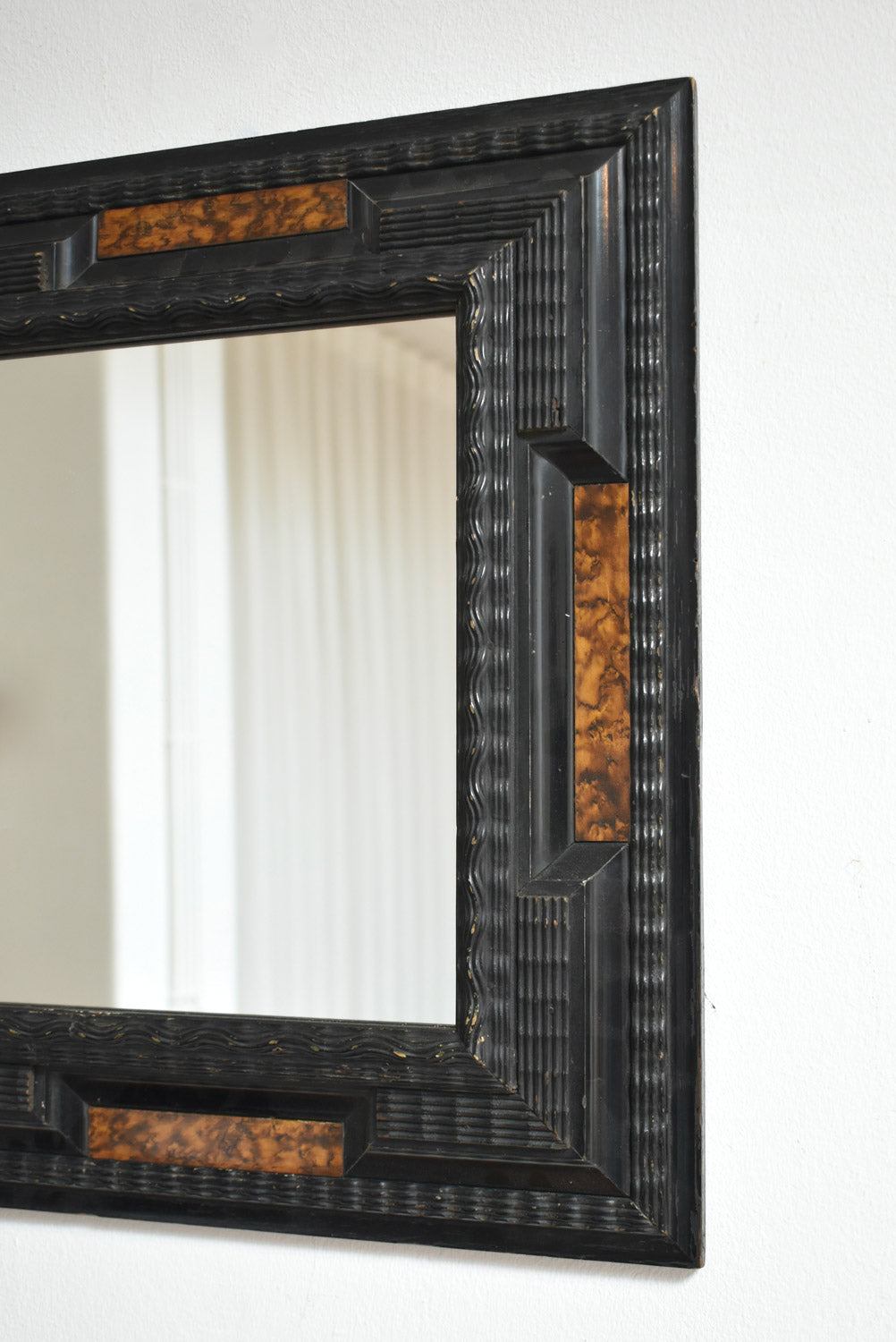 Pair of carved ebonised wood and trompe l'oeil turshell mirrors, XIXth c.