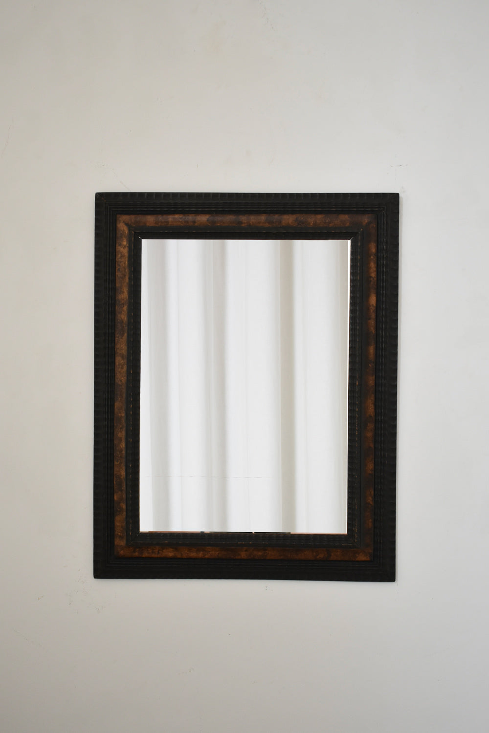 Carved ebonised wood mirror and trompe l'oeil turshell, XIXth c.