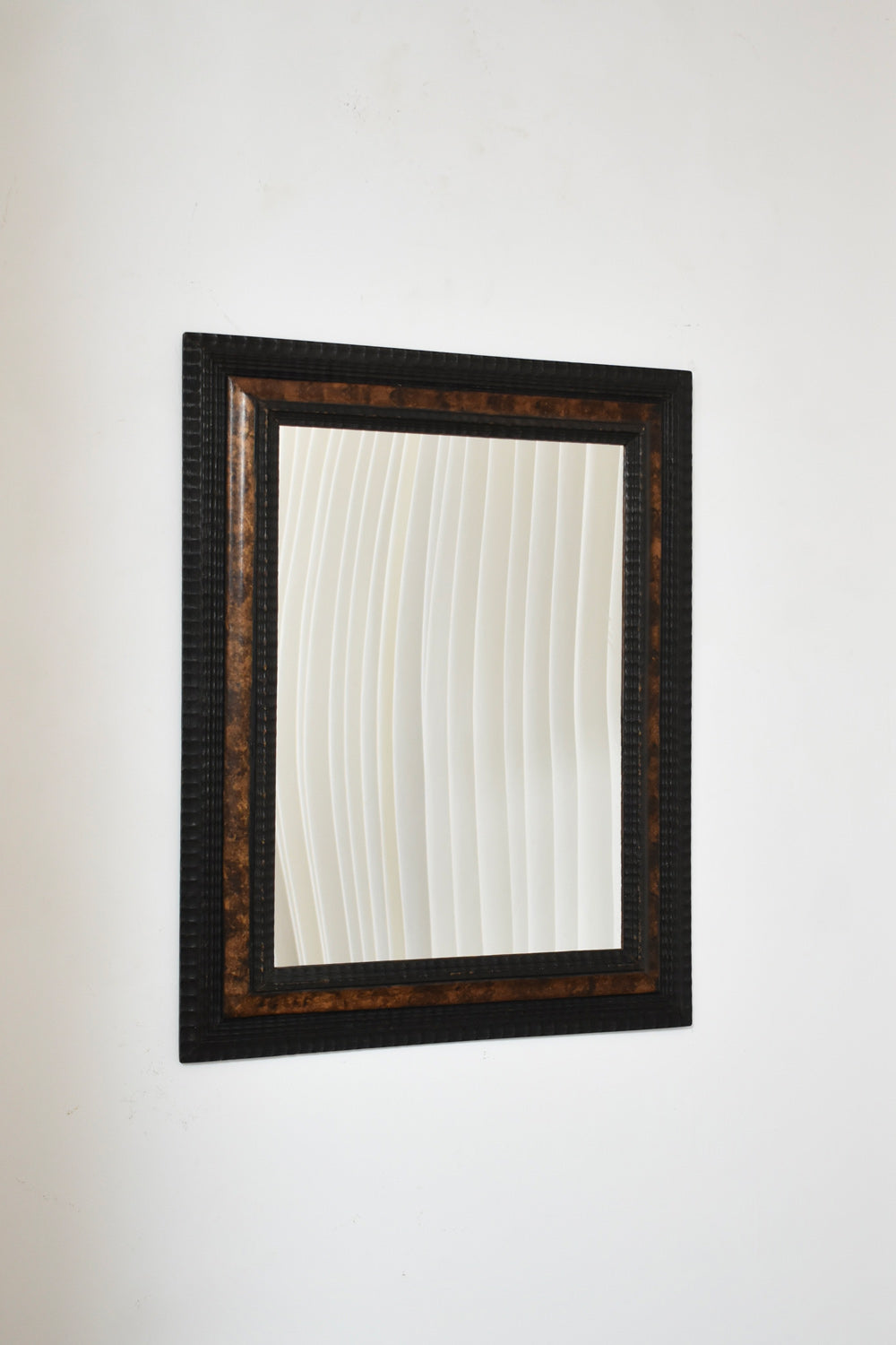 Carved ebonised wood mirror and trompe l'oeil turshell, XIXth c.