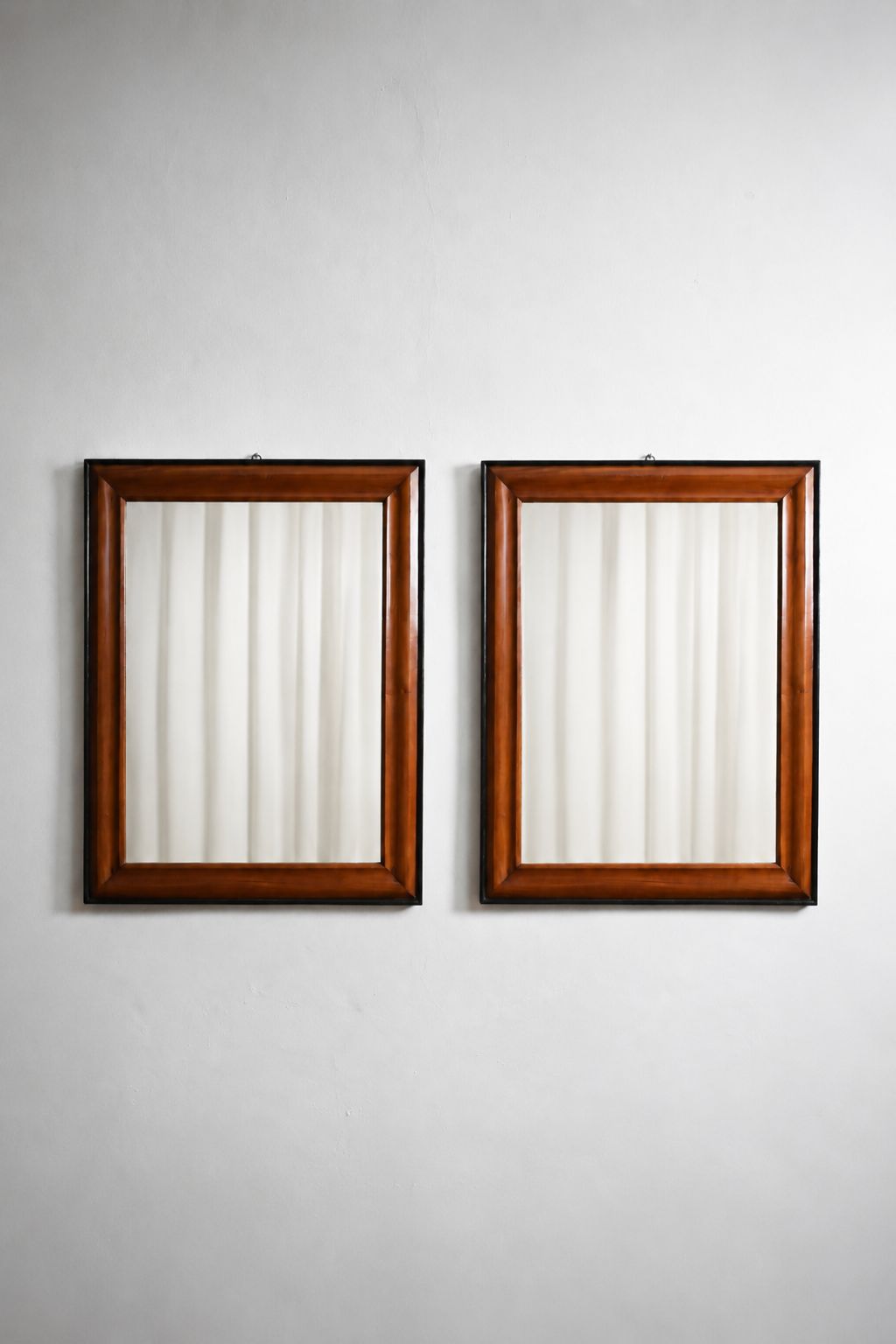 Pair of bicolor wood and ebonised wood mirrors, XIXth c.